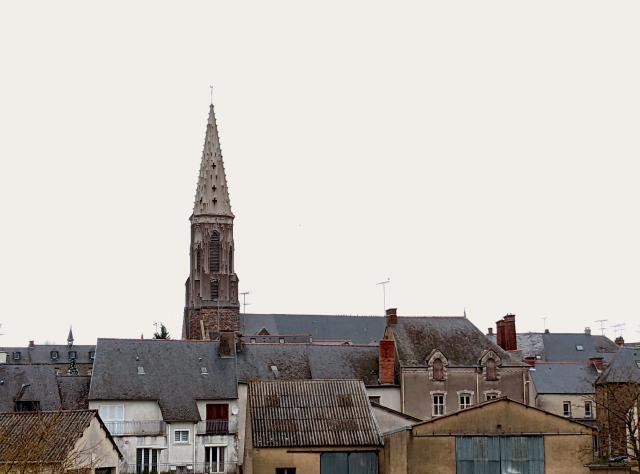 Houses overlooked by a church bell tower. The sky is white.