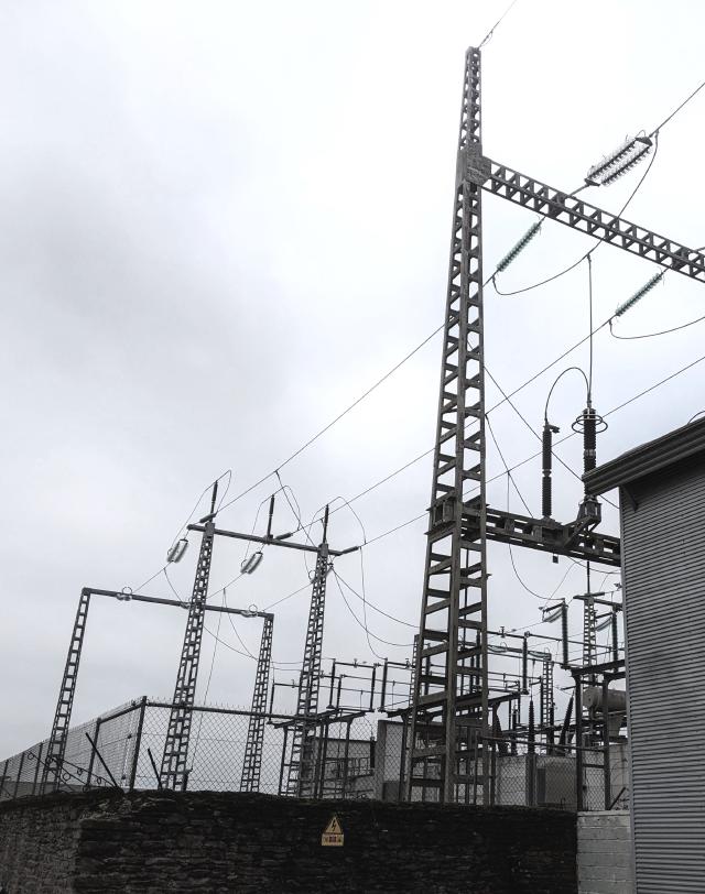 Menacing looking electrical infrastructure. The weather is not good, The sky is grey / white.